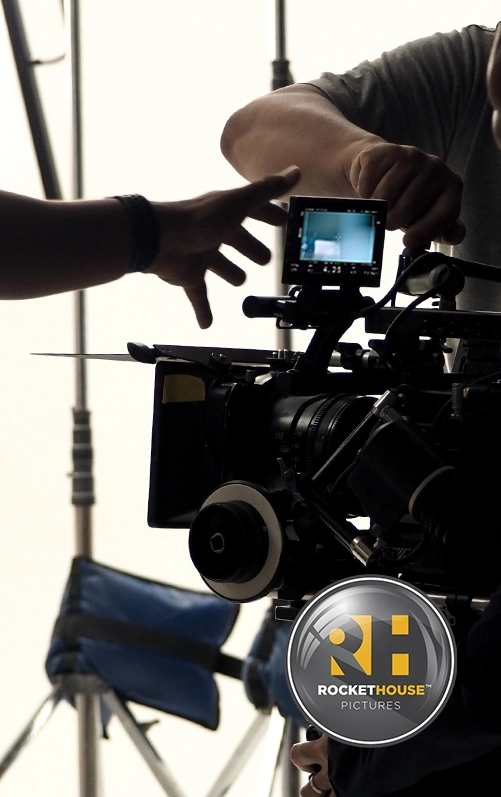 A camera crew works on a cinema camera inside a studio