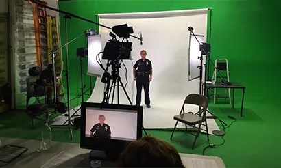 A man sits in a green screen studio.
